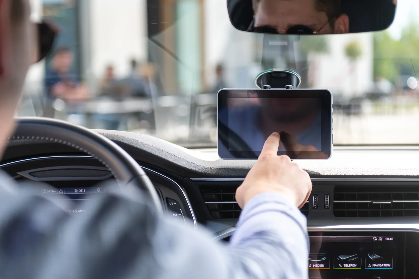 Fahrer bucht am Fahrzeug-Tablet im Auto