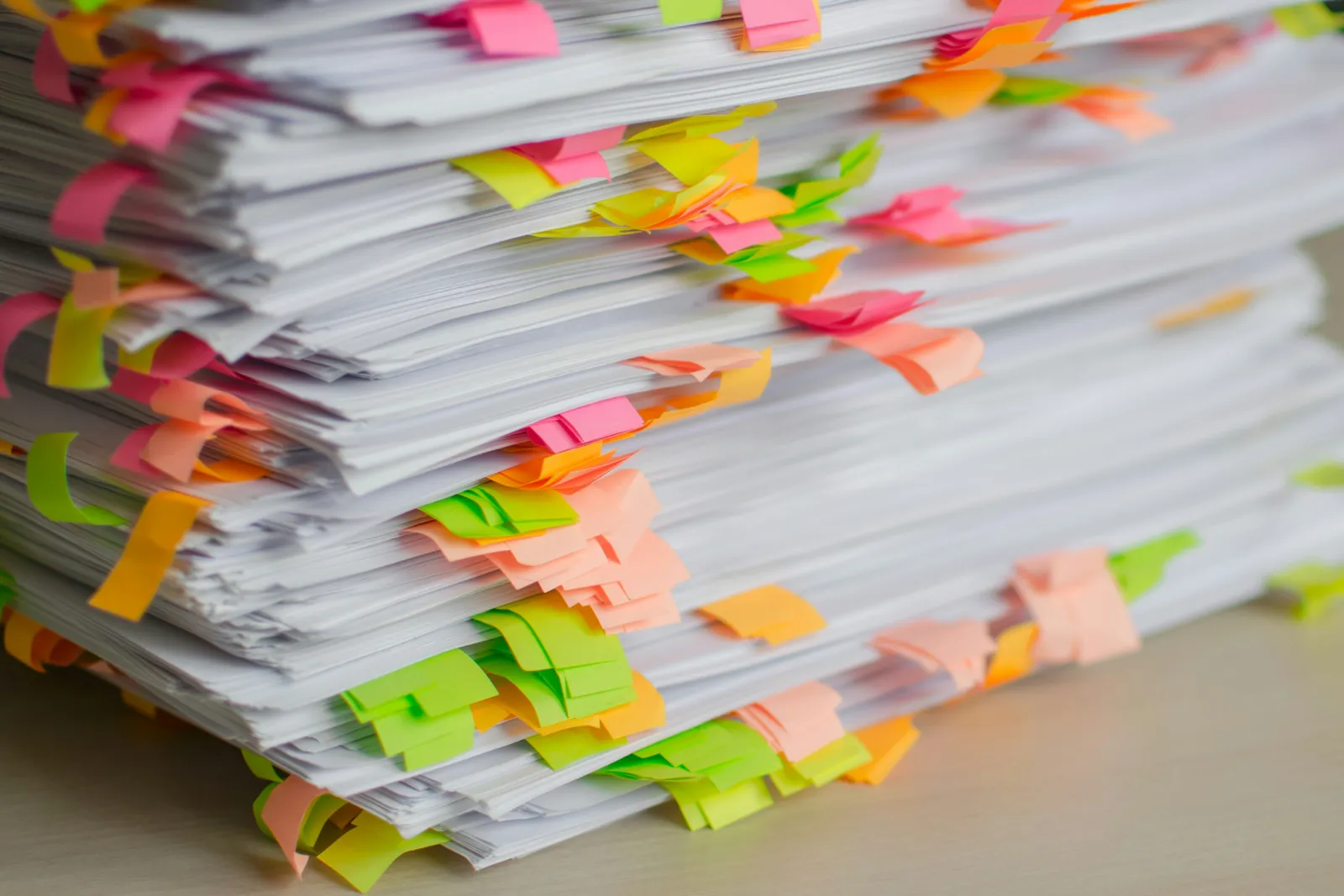 Stapel Papierunterlagen mit bunten Haftnotizen