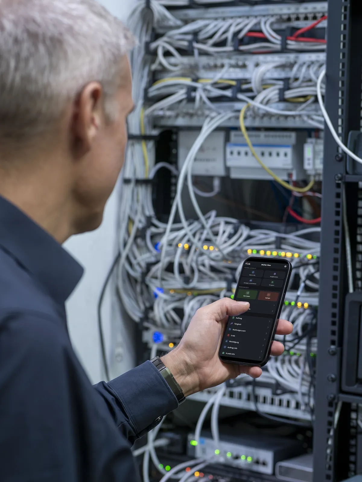 Techniker bucht im Serverraum am Smartphone