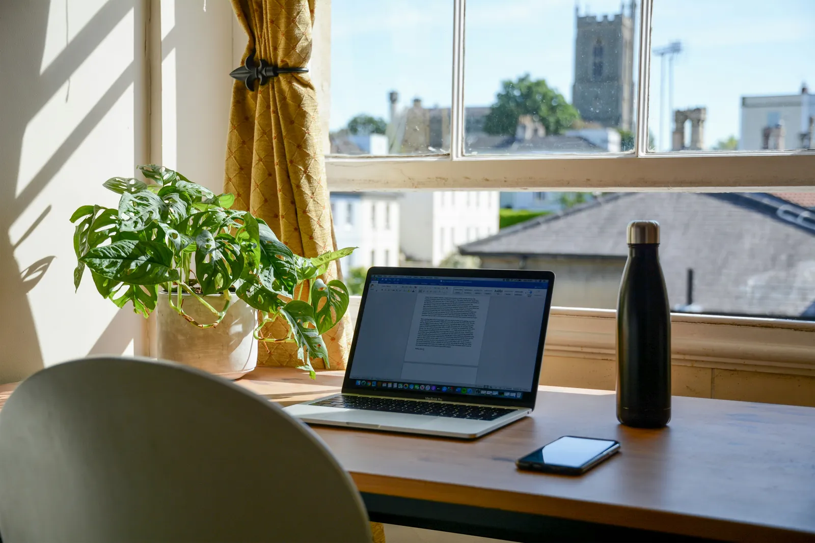 Arbeitsplatz im Homeoffice mit Laptop am Fenster