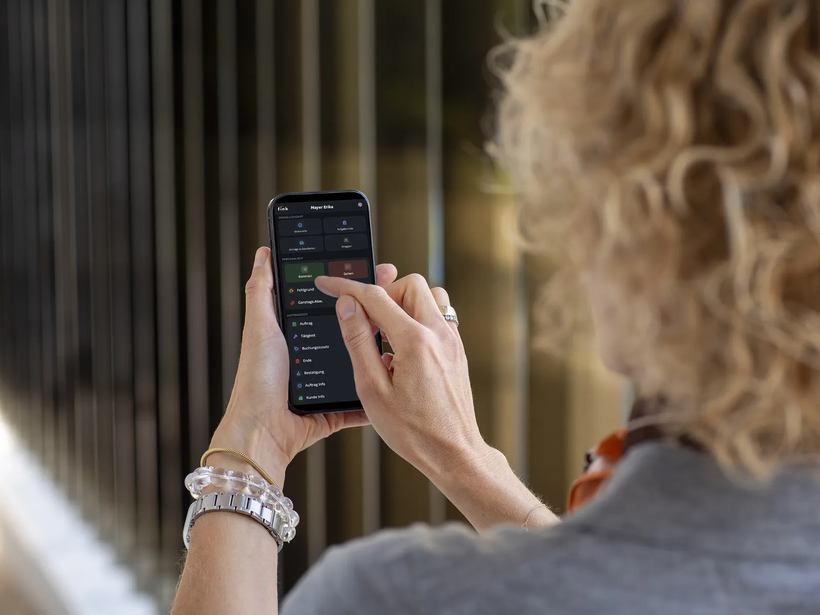 Mitarbeiterin stellt in der Fink Mobilversion am Smartphone einen Antrag
