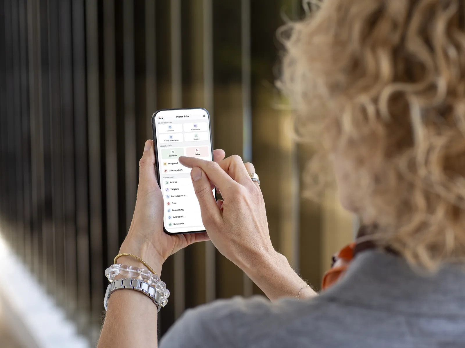 Mitarbeiterin mit der Fink Mobilversion am Smartphone